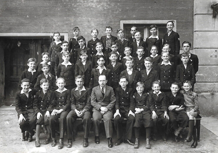 Lata 30. Zdjęcie klasowe, prawdopodobnie uczniów z klasy Andrzeja Komierowskiego w Gimnazjum im. Mikołaja Kopernika w Bydgoszczy. Andrzej Komierowski może być chłopcem, który siedzi w pierwszym rzędzie, trzeci od lewej strony. Jako uczeń tej szkoły wyjechał na wycieczkę do Lwowa i okolic.